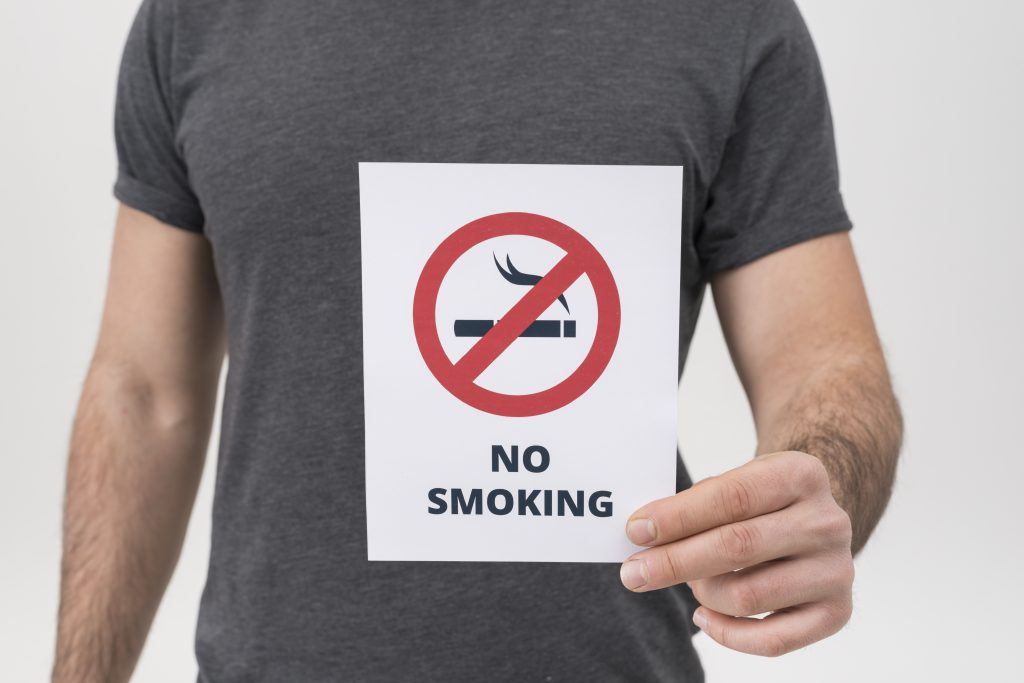 Man holding No Smoking Sign