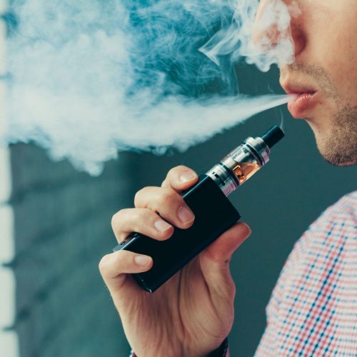Close up on a man exhaling vapor from an electronic cigarette Close up on a man exhaling vapor from an electronic cigarette