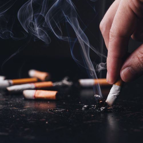 Close up hand held a cigarette to crush smoke of a burning, Stop Close up hand held a cigarette to crush smoke of a burning, Stop smoking concept.